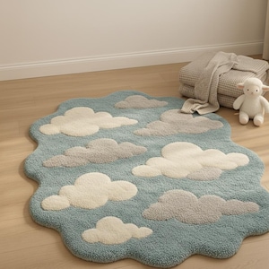 May include: A whimsical, cloud-shaped rug in shades of blue, white, and gray. The rug features a tufted design with fluffy cloud shapes scattered across a light blue background. A soft, decorative accent for a nursery or playroom.