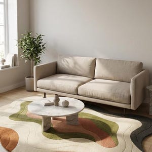 May include: A modern living room scene featuring a beige sofa, a round marble coffee table, and a unique rug with an abstract wave design in shades of green, orange, and cream. A potted plant and window are also visible.