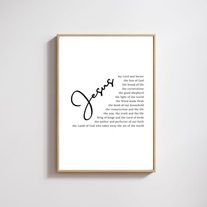Puede incluir: Una impresión enmarcada con la palabra "Jesús" en elegante escritura cursiva. La impresión presenta una lista de frases religiosas en un diseño minimalista, ideal para la decoración del hogar. El marco es de color marrón claro.