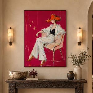 Può includere: Un'opera d'arte murale rettangolare che presenta un dipinto stilizzato di una persona con un cappello arancione a tesa larga, un top nero e pantaloni bianchi, seduta su una sedia su uno sfondo magenta vibrante con stelle gialle.