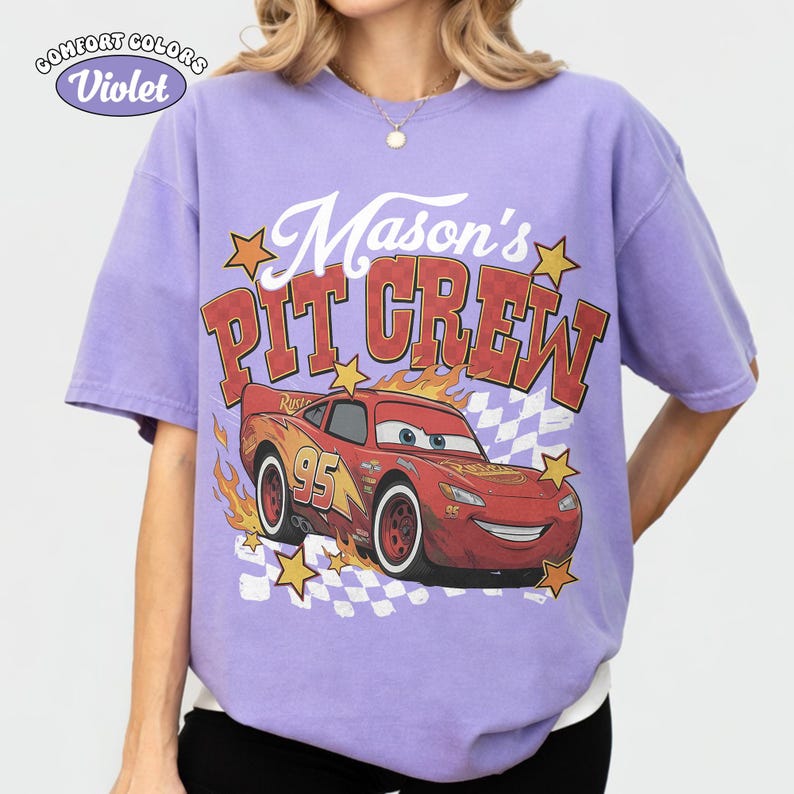 May include: A violet Comfort Colors t-shirt featuring a graphic of Lightning McQueen from the movie Cars. The design includes the text "Mason's PIT CREW" and the number "95" on the car. The shirt has a relaxed fit.
