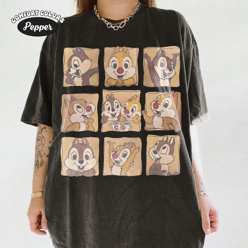 May include: Dark grey Comfort Colors t-shirt with a grid of Chip and Dale cartoon images. The cartoon characters are in various poses, set against a beige background. The shirt has the text "Comfort Colors Pepper" in a circular design.