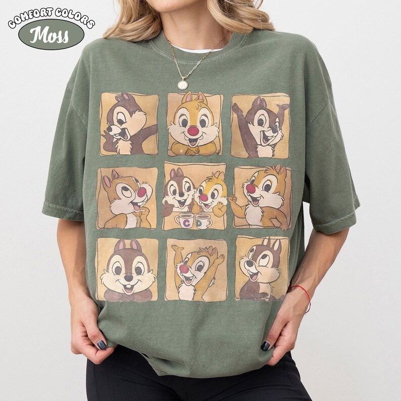 May include: Moss green Comfort Colors t-shirt with a grid of nine cartoon chipmunk images. The chipmunks are in different poses, set against a light brown background. The shirt has short sleeves and a relaxed fit. The Comfort Colors logo is in the upper left corner.
