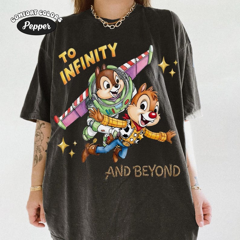 May include: Dark gray Comfort Colors t-shirt featuring Chip and Dale as Buzz Lightyear and Woody from Toy Story, with the text "TO INFINITY AND BEYOND". The design includes a colorful space-themed wing and star accents.
