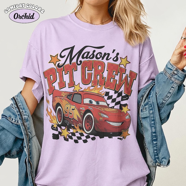 May include: A light purple Comfort Colors t-shirt with the text "Mason's PIT CREW" above a cartoon image of the character Lightning McQueen from the movie Cars. The graphic includes flames, stars, and a checkered flag.