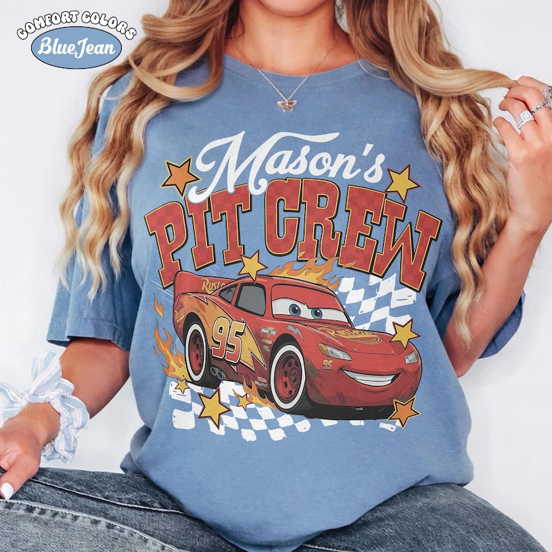 May include: Blue t-shirt with the text "Mason's Pit Crew" and a graphic of the character Lightning McQueen from the movie Cars. The shirt also features the Comfort Colors and Blue Jean logos.
