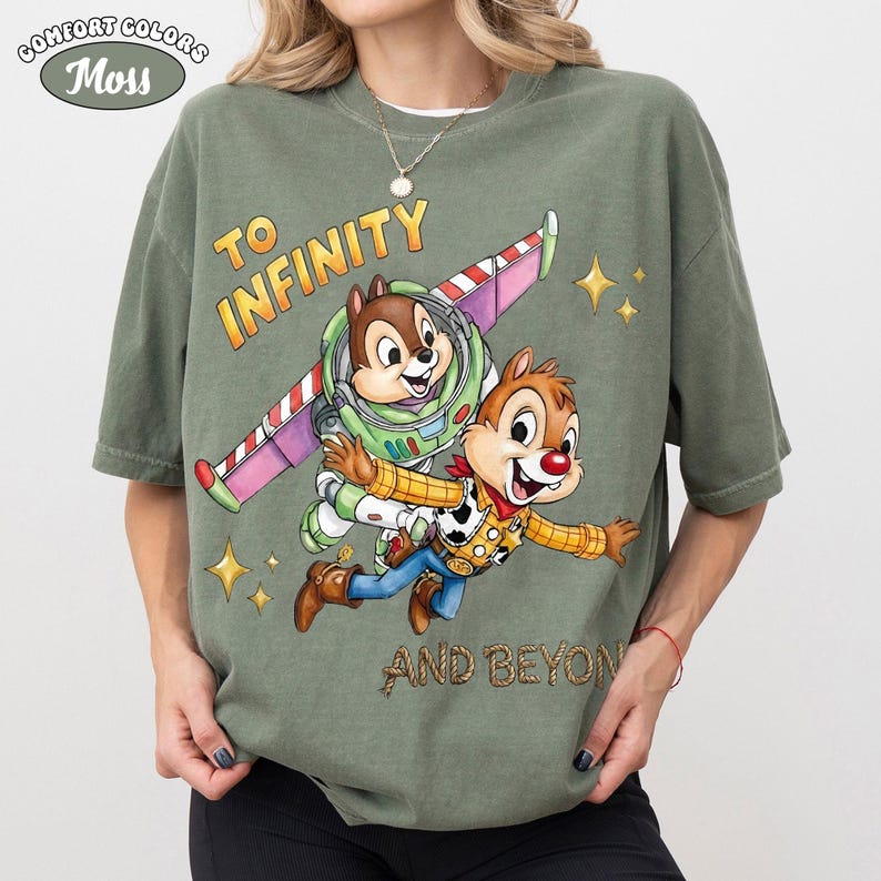 May include: Moss green Comfort Colors t-shirt featuring a graphic of Chip and Dale as Buzz Lightyear and Woody, with the text "TO INFINITY AND BEYOND". The shirt has a relaxed fit.