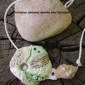 Può includere: Una collana fatta a mano con un ciondolo con forme e texture organiche, tra cui una conchiglia e una pietra. Il ciondolo è bianco, verde e beige, con un cordino bianco intrecciato. Il testo "TUTORIAL ORGANIC SHAPES AND TEXTURES" è visibile.