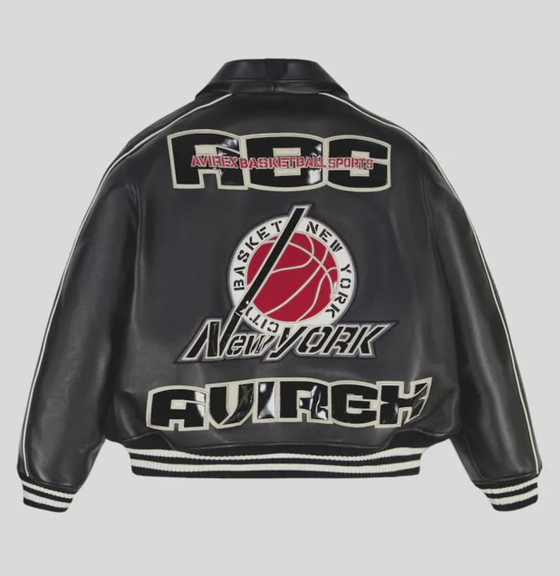 Puede incluir: Chaqueta de cuero negra con detalles blancos y dobladillo acanalado. Presenta el texto "RGS AVIREX BASKETBALL SPORTS" en los hombros y un gr&aacute;fico de baloncesto con el texto "New York". Una chaqueta cl&aacute;sica de tem&aacute;tica deportiva.