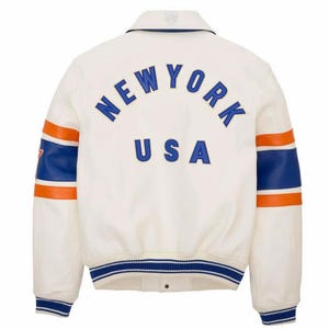 May include: Cream-colored varsity jacket with blue and orange accents. The back features the text "NEW YORK USA" in blue lettering. The sleeves have blue and orange stripes. The jacket has a collared neckline and a striped blue and white ribbed hem.