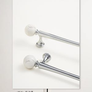 May include: Two curtain rods with white marble-effect ball finials and polished silver-tone hardware. The rods are angled diagonally against a white background, showcasing their design. The rods are designed for window treatments.