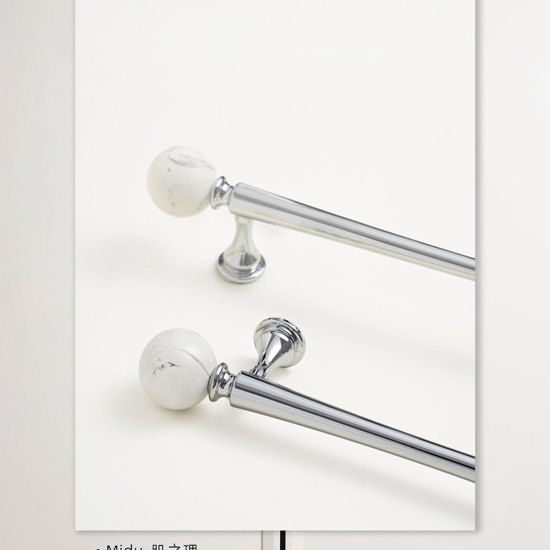 May include: Two curtain rods with white marble-effect ball finials and polished silver-tone hardware. The rods are angled diagonally against a white background, showcasing their design. The rods are designed for window treatments.