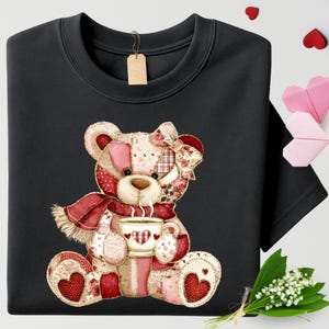 May include: Black sweatshirt featuring a patchwork teddy bear design. The bear wears a red scarf and holds a cup of coffee. The bear's design includes hearts and floral patterns. A blank tag hangs from the neckline.