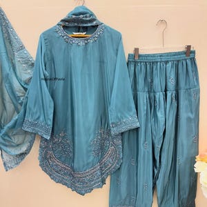 Könnte beinhalten: Ein Set aus drei Keramikbechern mit gesprenkelter, matter Oberfläche. Die Becher sind in Creme-, Hellgrau- und Dunkelgrautönen gehalten. Jeder Becher hat ein schlichtes, minimalistisches Design und einen abgerundeten Henkel.