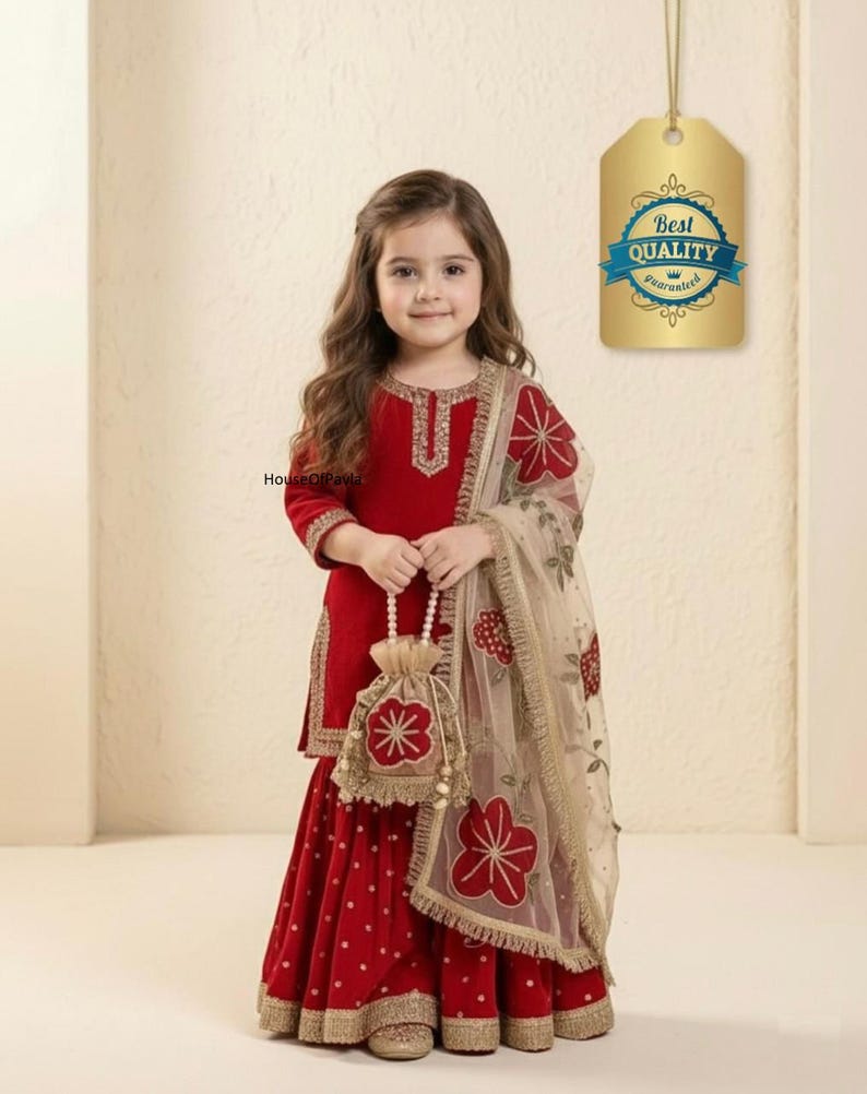 May include: A young girl in a red outfit with gold trim, holding a matching purse. The outfit includes a long-sleeved top and a skirt with white polka dots. A sheer scarf with floral embroidery completes the ensemble. A tag with "Best Quality Guaranteed" is visible.