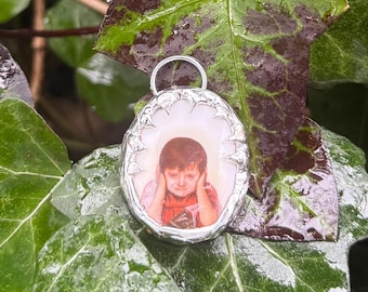 Dije de cerámica de niña triste