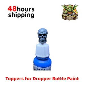 May include: A blue dropper bottle of paint with a skull-shaped topper. The bottle has a white cap and a label with text. The image also includes the text "Toppers for Dropper Bottle Paint".