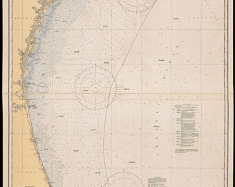 May include: A nautical chart titled Charleston Light to Cape Canaveral, depicting the United States East Coast. The map features depth soundings, compass roses, and notations for sand and coral sea floor compositions across the Atlantic Ocean.