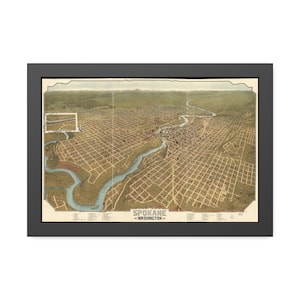 May include: A framed historical bird's-eye view map of Spokane, Washington, featuring a winding river, a grid of city streets, and surrounding landscape. The print includes the text 'SPOKANE WASHINGTON' at the bottom center with a legend.