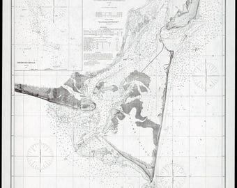 May include: A black and white nautical chart titled Cape Fear River, North Carolina, featuring detailed coastal topography, depth soundings, Frying Pan Shoals, and Smith Island. The map includes compass roses, tidal data, and administrative text.