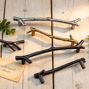 Puede incluir: Un juego de tres tazas de cerámica con un acabado mate moteado. Las tazas son de color crema, gris claro y gris oscuro. Cada taza tiene un diseño simple y minimalista.