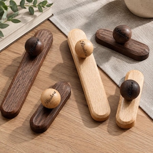 May include: Five wooden drawer pulls, each consisting of a rectangular base and a spherical knob. Three pulls are made of dark brown wood with light brown knobs, and two are made of light tan wood with dark brown knobs. Each knob features the word Pandora.