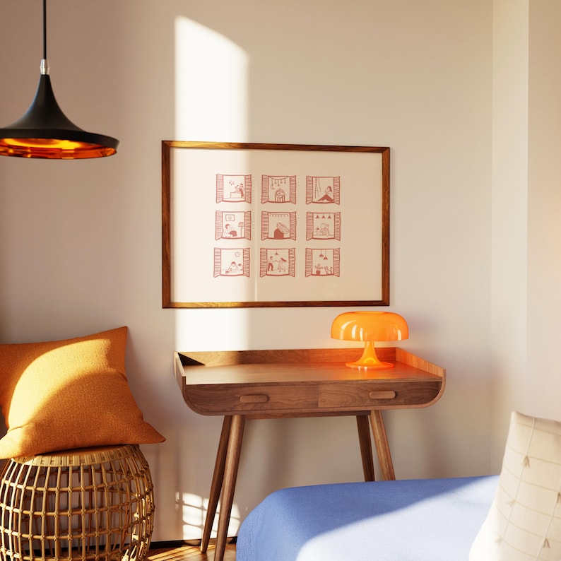 K&ouml;nnte beinhalten: Ein Holzschreibtisch mit einer Schublade und drei Beinen, gekr&ouml;nt von einer orangefarbenen Lampe. Ein gerahmter Druck mit neun Fensterillustrationen h&auml;ngt &uuml;ber dem Schreibtisch. Ein orangefarbenes Kissen liegt auf einem gewebten Hocker. Eine schwarze und goldene Pendelleuchte h&auml;ngt von der Decke.