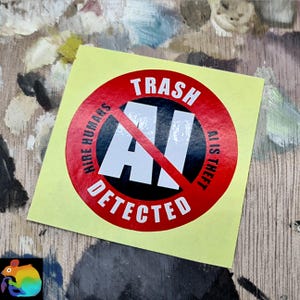 Könnte beinhalten: Ein gelber Aufkleber mit einem roten Kreis und den weißen Wörtern "TRASH" und "DETECTED". Die Buchstaben "AI" sind mit einer roten Linie durchgestrichen. Der Text "HIRE HUMANS" und "AI IS THEFT" ist ebenfalls enthalten.