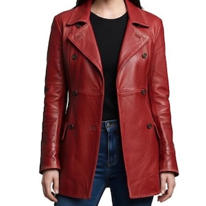 May include: A red leather double-breasted coat with a notched collar and multiple dark buttons. The coat has long sleeves and a tailored fit. The model is wearing a black shirt and blue jeans.
