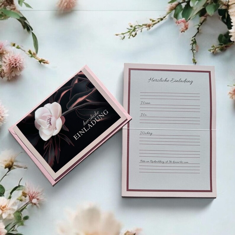 Peut inclure: Ensemble de cartons d'invitation roses avec un motif floral. Le recto de la carte pr&eacute;sente une fleur blanche sur fond noir avec les mots "herzliche EINLADUNG". La carte ouverte a des lignes pour les d&eacute;tails de l'&eacute;v&eacute;nement.