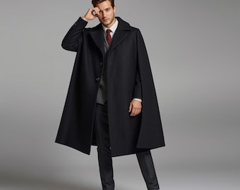 May include: A black wool cape coat with a classic design. The coat features a button-down front, a wide collar, and a tailored fit. The model is wearing a white shirt, a gray vest, a red tie, and black dress pants.
