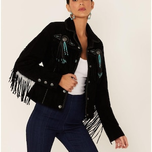 May include: Black suede jacket with fringe detailing on the sleeves and hem. The jacket features decorative embellishments with turquoise-coloured beads and silver studs. The jacket has a classic collar and button closures.