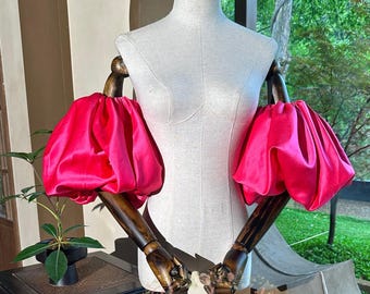 Mangas abullonadas de satén fucsia: accesorio elegante y extraíble para ocasiones especiales.