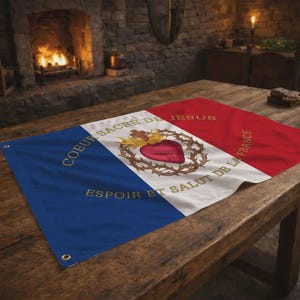 Peut inclure: Un drapeau rectangulaire avec des sections bleues, blanches et rouges, avec du texte doré et un emblème central. L'emblème comprend un cœur, une couronne d'épines et des flammes. Le drapeau est posé sur une table en bois.