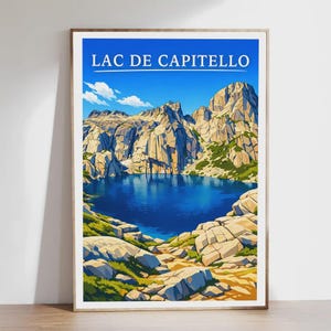 Könnte beinhalten: Ein gerahmter Kunstdruck mit einer malerischen Ansicht des Lac de Capitello. Das Kunstwerk zeigt einen ruhigen blauen See, umgeben von hoch aufragenden, zerklüfteten Bergen unter einem klaren blauen Himmel. Der Text "LAC DE CAPITELLO" ist oben zu sehen.
