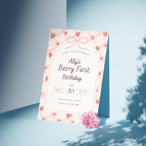 May include: A pink and white birthday invitation with a strawberry theme. The invitation reads "Ally's Berry First Birthday" with the date and time. The design includes strawberries, flowers, and a bow.