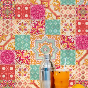 Puede incluir: Fondo de baldosas de colores con una coctelera, un vaso de zumo de naranja con pajita y fruta fresca. Las baldosas presentan diseños geométricos y florales en rojo, rosa, turquesa y amarillo.