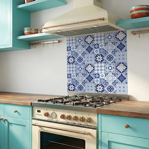 Puede incluir: Una cocina con una estufa y un protector contra salpicaduras estampado. El protector contra salpicaduras está hecho de azulejos azules y blancos con diseños geométricos y florales. Los armarios son de color azul claro y las encimeras de madera.