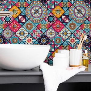 Puede incluir: Un mueble de baño con un lavabo blanco ovalado y un grifo cromado. El fondo presenta un papel pintado colorido con formas geométricas en tonos azules, rosas, amarillos y morados. Accesorios: cepillos de dientes, dispensador de jabón y toalla.