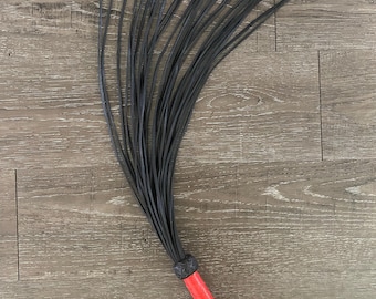 Látigo de cuero hecho a mano con mango rojo y colas negras de múltiples hebras, resistente, con correa de muñeca trenzada, accesorio sensorial para juegos de rol, regalo para parejas.