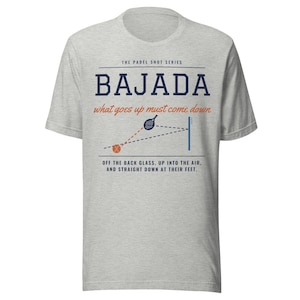 May include: A heather grey t-shirt featuring a graphic design about the padel shot Bajada. The text reads: THE PADEL SHOT SERIES BAJADA what goes up must come down OFF THE BACK GLASS, UP INTO THE AIR, AND STRAIGHT DOWN AT THEIR FEET.