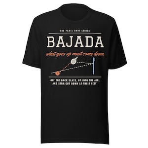 May include: A black t-shirt featuring a graphic design titled THE PADEL SHOT SERIES BAJADA. The print includes the text what goes up must come down, a diagram of a padel racket and ball, and the text OFF THE BACK GLASS, UP INTO THE AIR, AND STRAIGHT DOWN AT THEIR FEET.