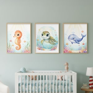 Peut inclure: Trois impressions encadrées à l'aquarelle représentant la vie marine. Les impressions représentent un hippocampe, une tortue de mer et une baleine, le tout dans un style fantaisiste. L'œuvre comprend du corail, des bulles et des poissons, avec une palette de couleurs douces de bleus, d'oranges et de verts.