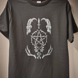 May include: Black t-shirt with a white pentagram design. The pentagram is surrounded by thorns and two goat skulls. There are antlers on either side of the pentagram.