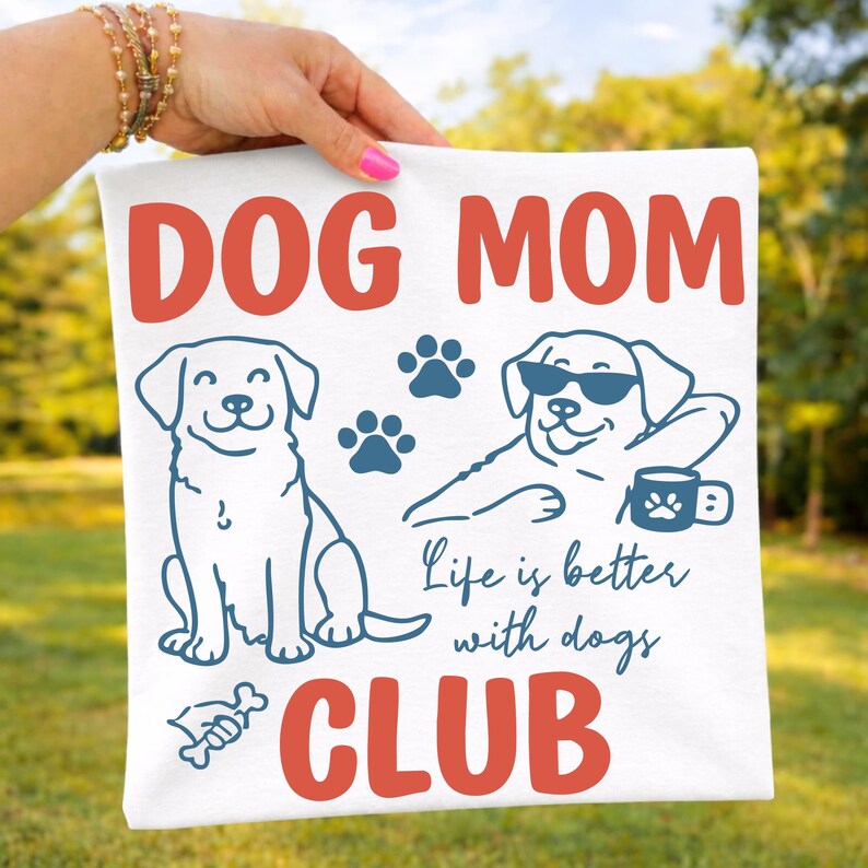 Dog Mom shirt mockup held outdoors featuring playful dog graphics, paw prints, and bold “Dog Mom Club” text. Perfect for dog owners, pet moms, and animal lovers. Great for Cricut, sublimation, and custom apparel.