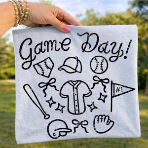 Può includere: Un tessuto quadrato azzurro con la scritta "Game Day!" e illustrazioni nere a tema baseball, tra cui una palla, una mazza, un guanto e un casco.