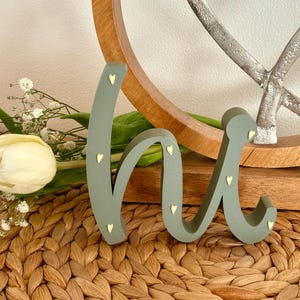 May include: A set of three ceramic mugs with a speckled, matte finish. The mugs are in shades of cream, light gray, and dark gray. Each mug has a simple, minimalist design and a rounded handle.