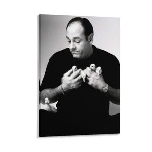 Puede incluir: Retrato en blanco y negro de un hombre con una camisa negra sosteniendo varios patitos blancos pequeños. El hombre mira a los patitos con una expresión suave. La imagen es una impresión en lienzo.