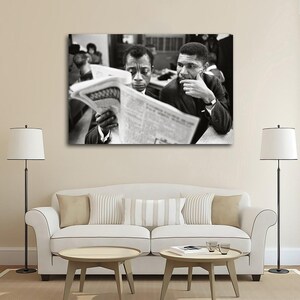 May include: Black and white photograph of two men reading a newspaper. One man is holding the newspaper, while the other is looking on with a thoughtful expression. The image is a portrait, likely of historical figures.