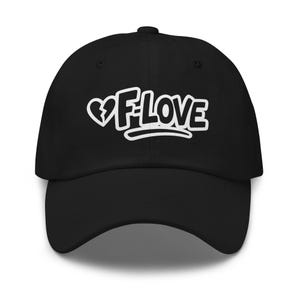 Puede incluir: Gorra de béisbol negra con el texto blanco "F-LOVE" y un gráfico de corazón roto. La gorra tiene una visera curva y una corona redondeada. El texto está en una fuente en negrita y estilizada.